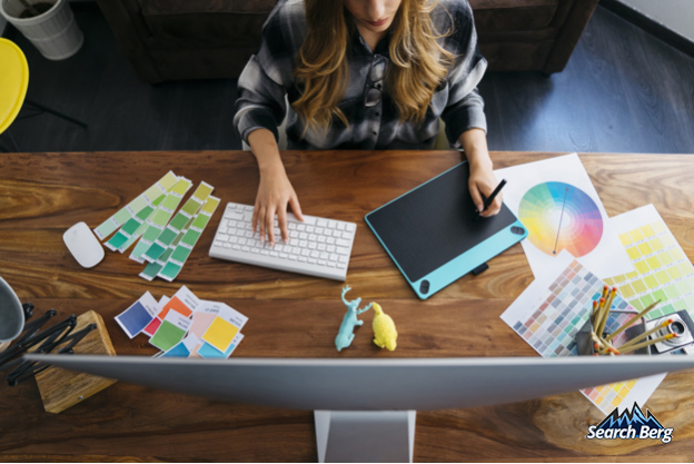 a woman using a drawing tablet and a pen to create graphic designs